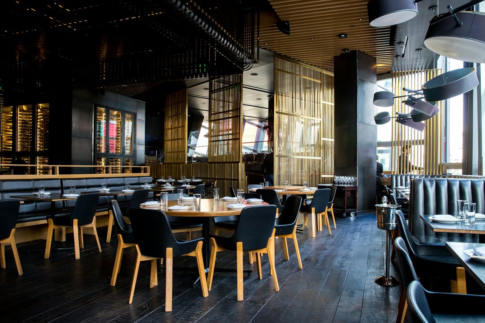 An open-air waterfront restaurant glowing softly as dusk settles over the sea